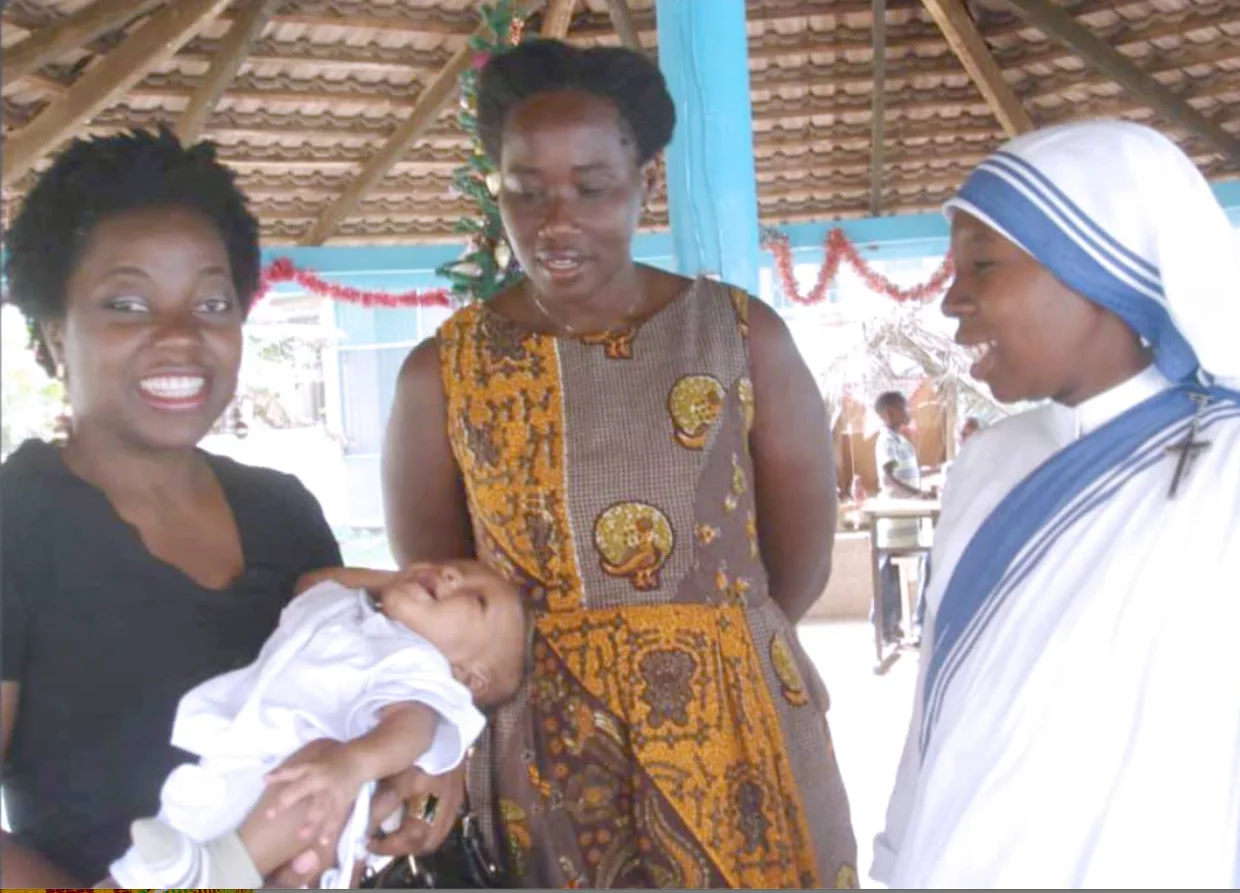 A Missionary of Charity supporting a mother and child